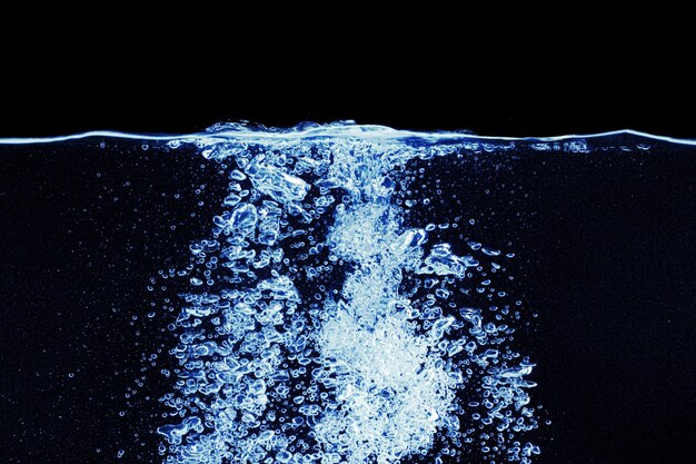 Photo water splash in aquarium isolated on black background close up