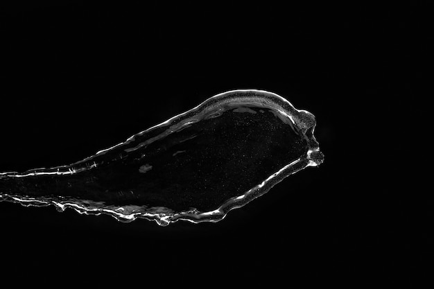 Water splash on black background. Flying clear liquid. Pouring transparent water