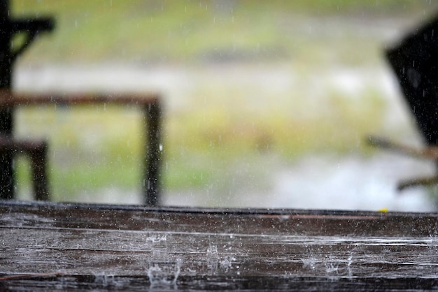 Water splash from raining on wooden table top