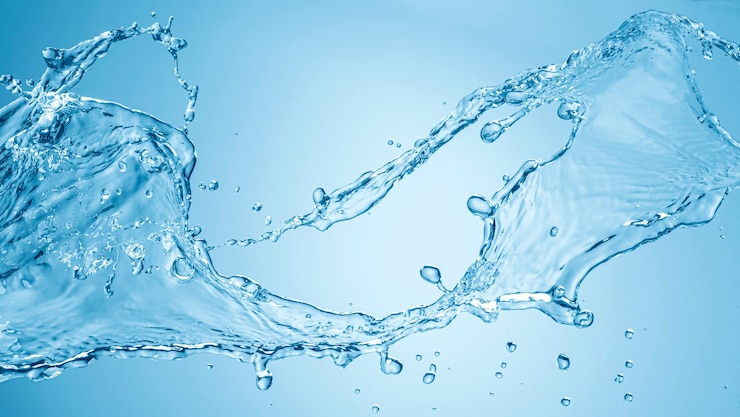 青い背景に分離された水のしぶき