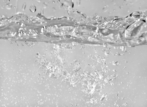 Water splashes as liquid is poured into the tank, abstract background.