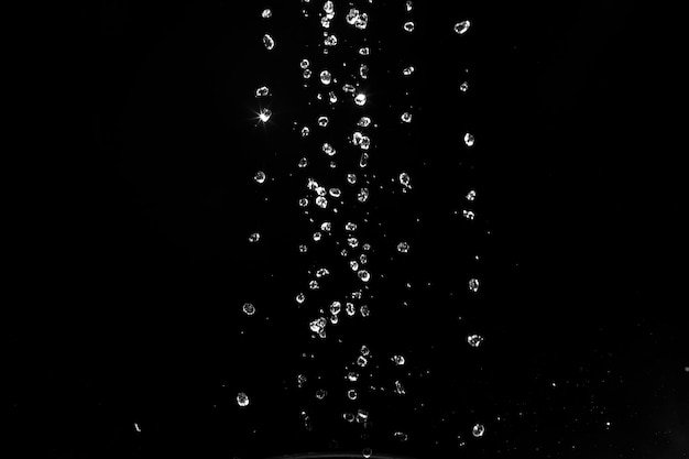 Foto spruzzi d'acqua isolati su sfondo nero getti bianchi con gocce