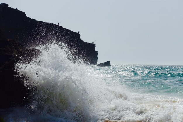 Water splashing in sea against clear sky