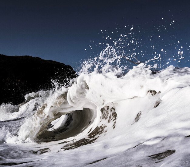 Water splashing in sea against clear sky