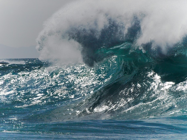 water splashing in sea against sky