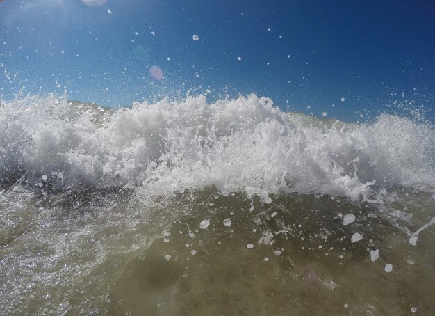 Photo water splashing in sea against sky