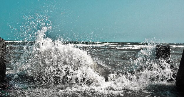 Photo water splashing in sea against sky