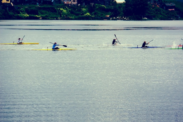 Люди, занимающиеся водными видами спорта, гребут на каноэ по реке
