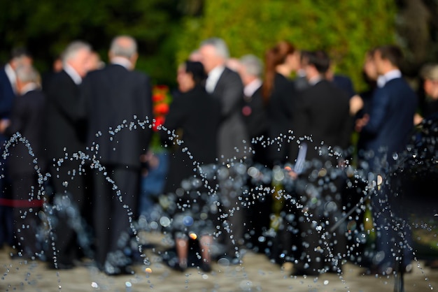 Foto spruzzatura d'acqua contro le persone al cimitero durante il funerale