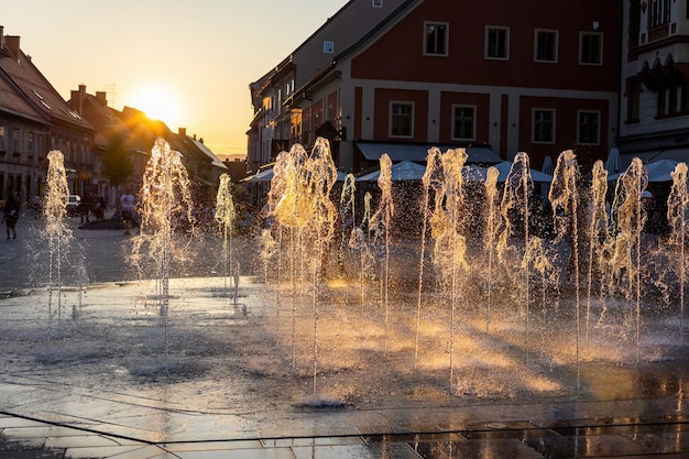 Spruzzatura d'acqua dalla fontana nella città di maribor slovenia al tramonto