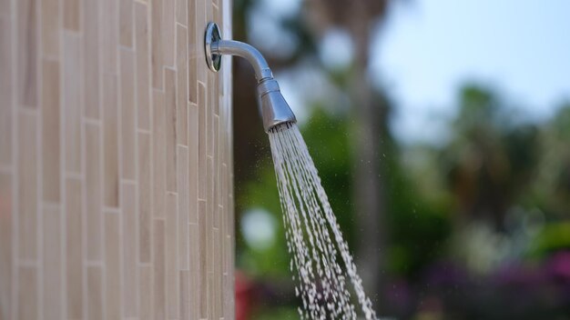 Water stroomt uit de douche bij het zwembad in de hotelclose-up