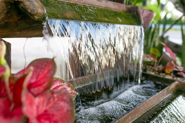 Water stroomt uit een fontein in de tuin close-up van de foto