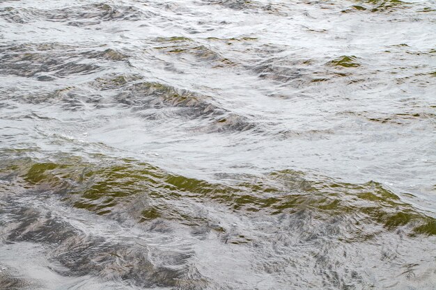 Foto superficie d'acqua del mare con onde verdi in close-up in tempo nuvoloso