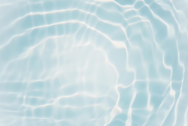 The water surface of a swimming pool with the sun reflecting on it.