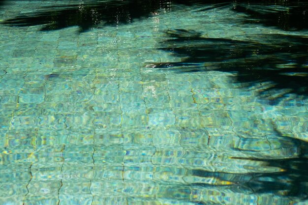 Water surface In swimming pool with sunny reflections and shadows