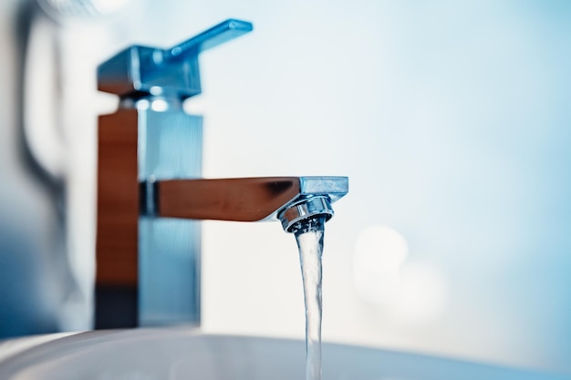 Foto rubinetto del rubinetto dell'acqua flusso d'acqua nel bagno con lavandino casa moderna e pulita concetto di igiene panorama