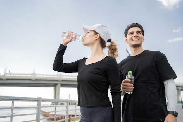 Water uit plastic flessen Fitness mannelijke en vrouwelijke hardloper die een actieve training doen