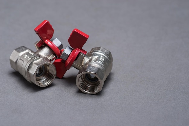Photo water valves with red handle on grey