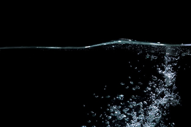 Photo water wave with air bubbles water on black background.