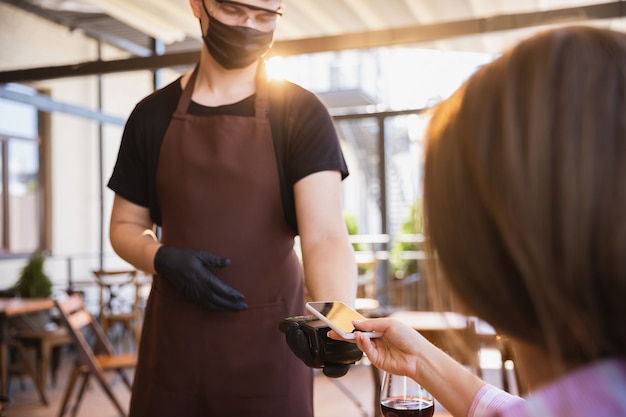 Water werkt met gezichtsmasker in restaurant, uitbraak van coronavirus