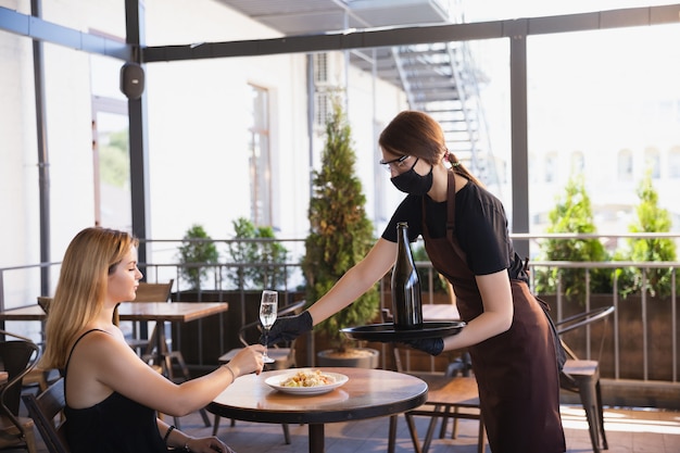 Water werkt met gezichtsmasker in restaurant, uitbraak van coronavirus