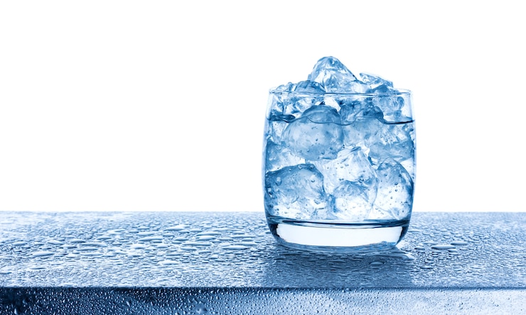 Photo water with crushed ice cubes in glass on white background