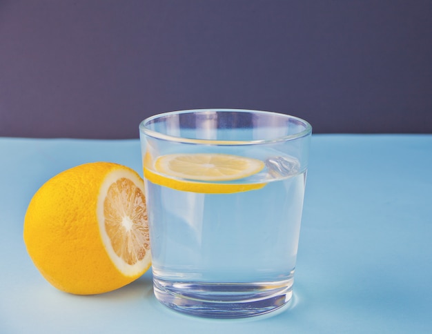 Water with lemon on the blue table