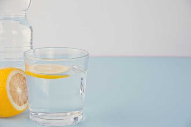 Water with lemon on the blue table