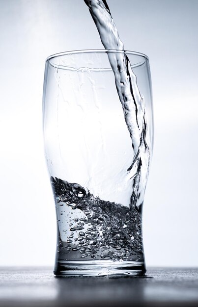 Water wordt van bovenaf in een glas gegoten