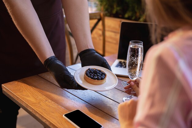 Acqua che lavora con maschera facciale nel ristorante, focolaio di coronavirus