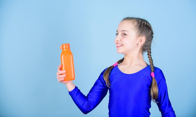 Waterbalans en harde gymtraining Drink meer water Houd een waterfles bij je Les dorst Kind voelt dorst na sporttraining Kid schattig meisje gymnast sportpakje houd fles vast voor drinken