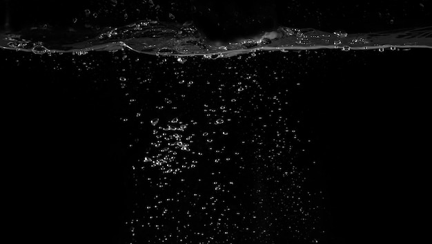 Waterbellen drijvend op een zwarte achtergrond die verfrissend of verfrissing vertegenwoordigen van frisdrank of koolzuurhoudende drank en kracht van vloeistof die spettert of bruist met blazen en stromen door luchtpomp