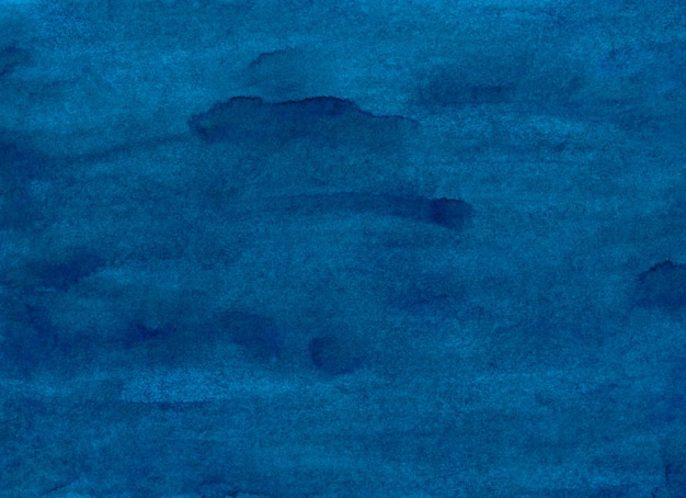 水彩の紺碧の背景テクスチャ、紙の汚れ。手描きの濃い青のラフな水彩画。