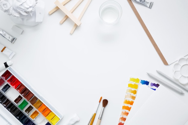 Watercolor and other artistic accessories on a white background Artist's desk workplace