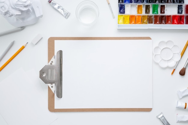 Watercolor and other artistic accessories on a white background Artist's desk workplace