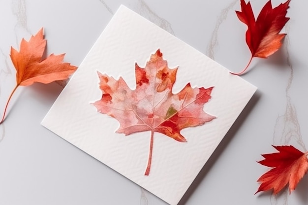 A watercolor painting of a maple leaf is on a white surface.