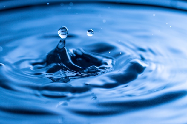 Waterdruppel plons in een blauw gekleurd glas