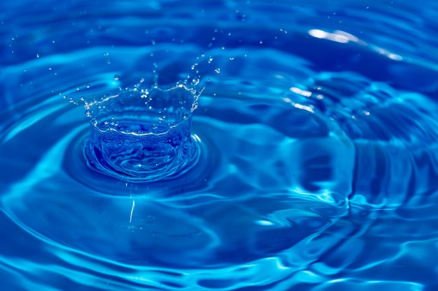 Foto waterdruppel plons in een blauw gekleurd glas