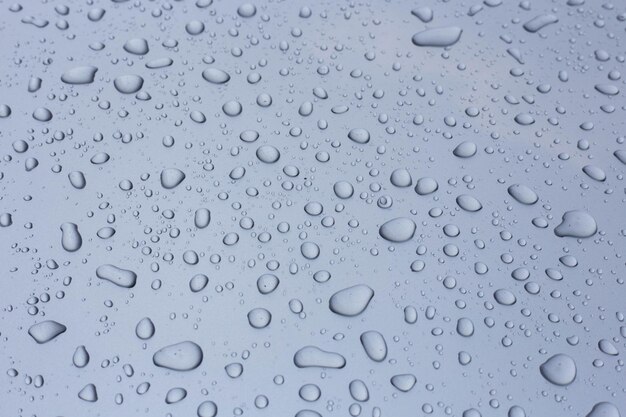 Waterdruppels op de motorkap in zilver op een hete zonnige dag