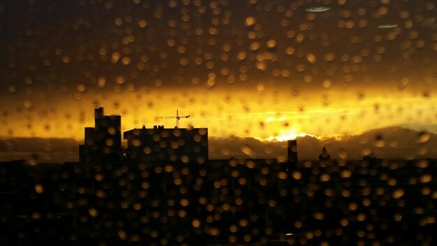 Foto waterdruppels op glas tegen silhouetstructuren