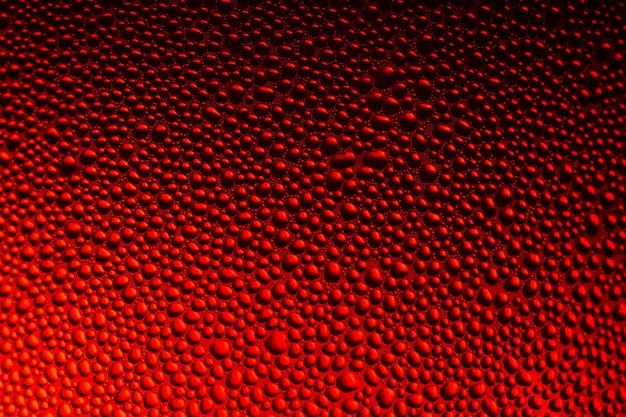 Waterdruppels op het glas met een rode verlichting
