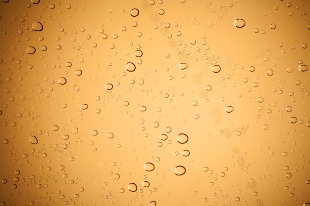 Waterdruppeltjes op bruin glas voor een achtergrond, Regendruppels op bruin glas, Druppels water