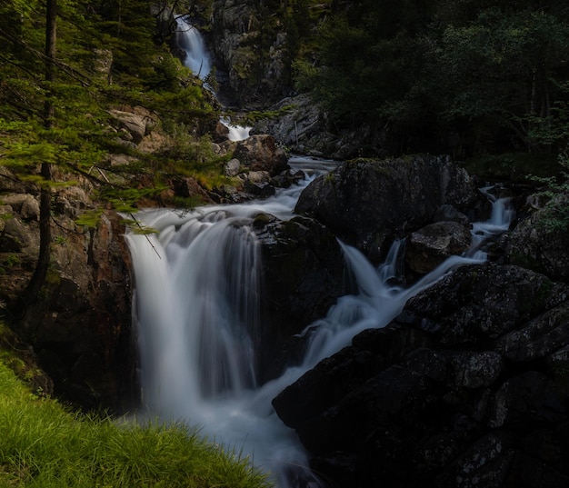 Waterfall falling slowly from the Gorgas del Alba in the Benasque Valley Illumination of dawn with magical and esoteric light