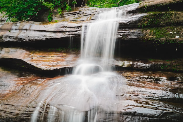 Photo waterfall flowing through rocks in rainy season.