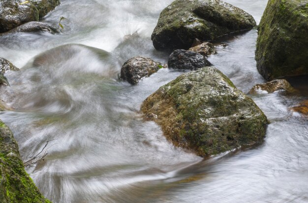 Photo waterfall flows through the rocks.