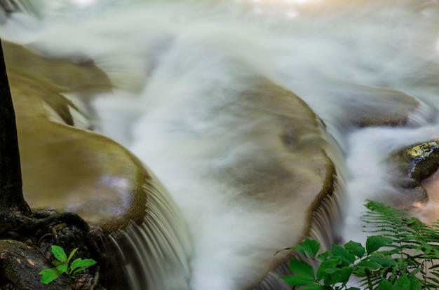 Photo waterfall flows through the rocks.