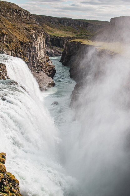 Photo a waterfall in iceland with a sign that says'the water is flowing '