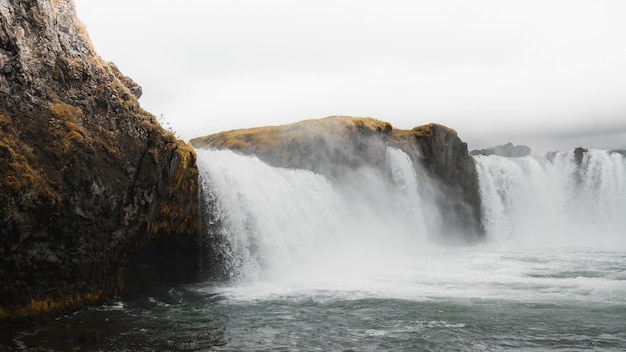 Photo waterfall on rocky cliffs in iceland