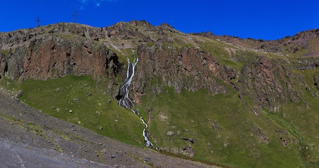 Waterfall on the rocky slopes of the Caucasus Mountains in Russia