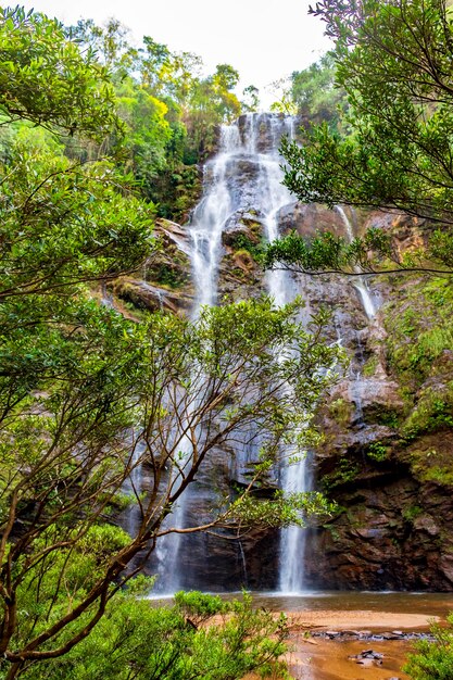 Waterfall seen through the vegetation of the dense tropical forest in Minas Gerais Brazil